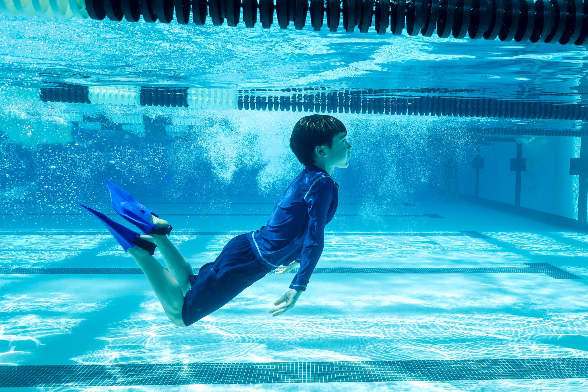 Boy diving underwater wearing flippers